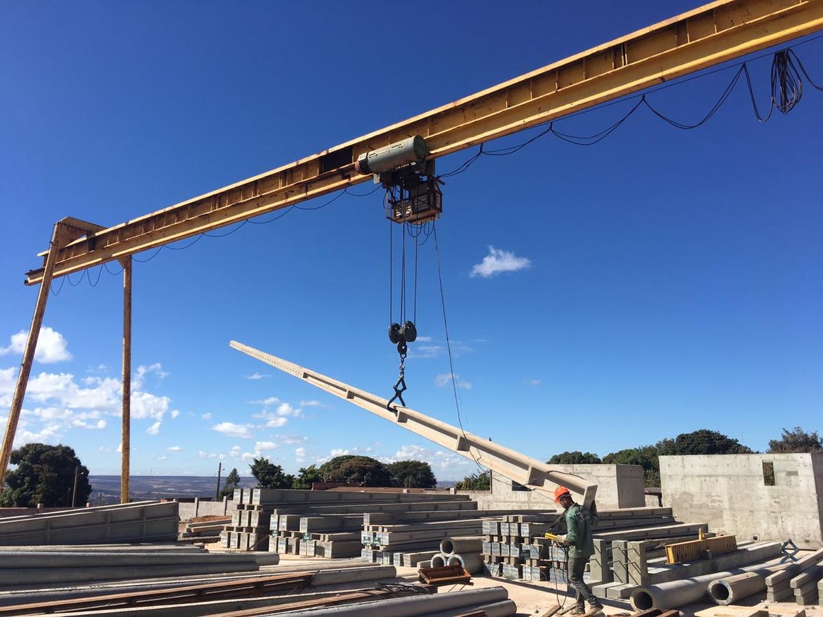 Ponte rolante movimentando peças de concreto na fábrica Reaal